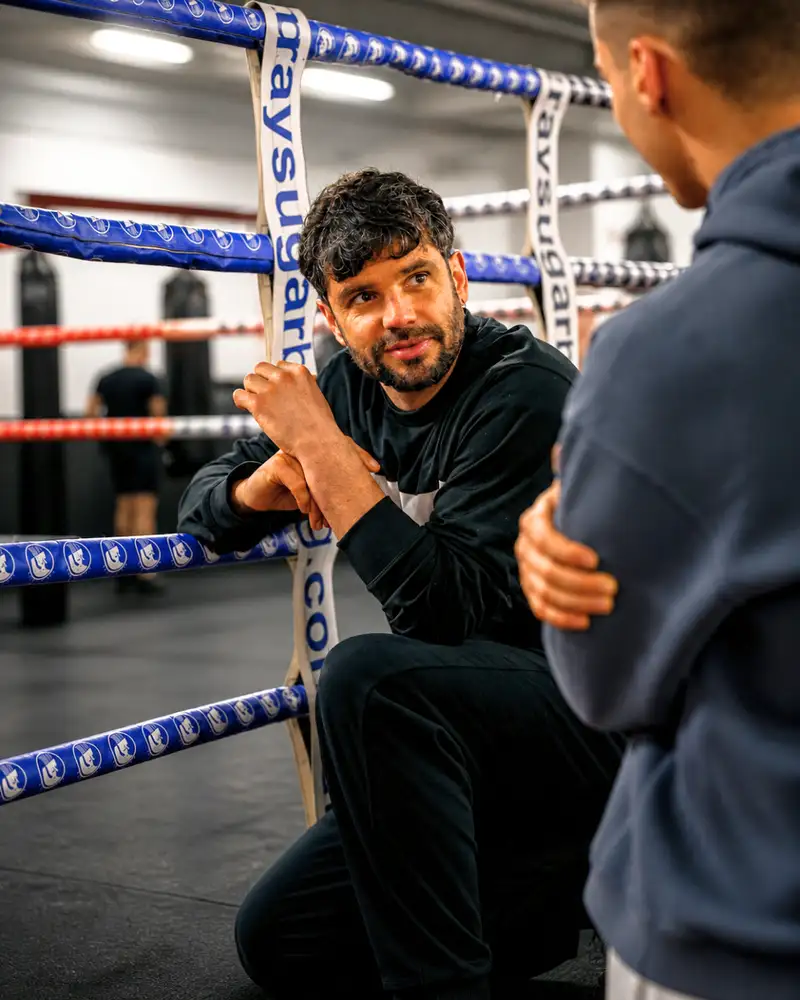 Entrenador corrigiendo técnica en el ring de Ilion Boxing Club Barcelona