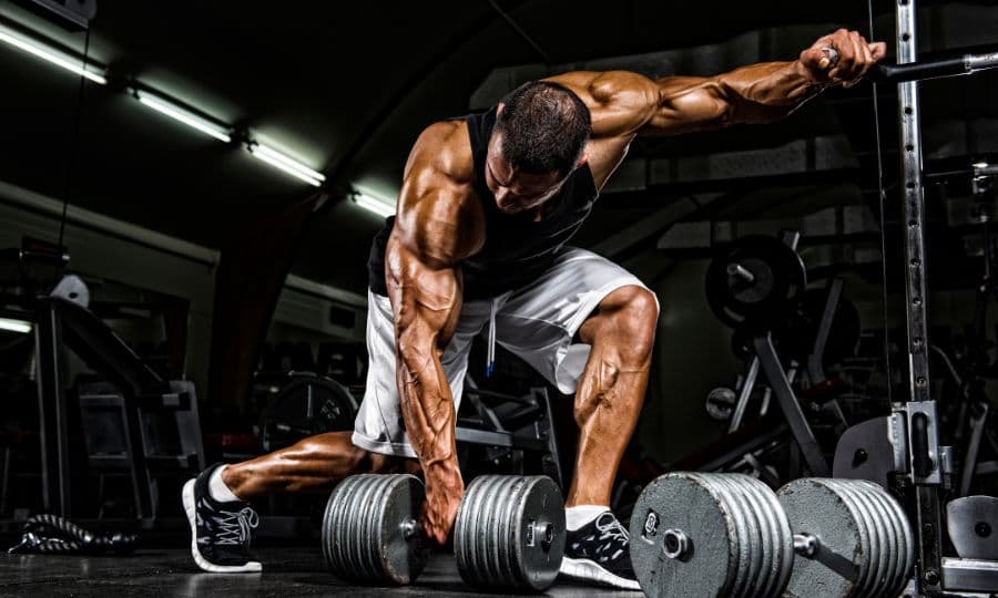 Deportista realizando ejercicios de cuerpo completo en el gimnasio